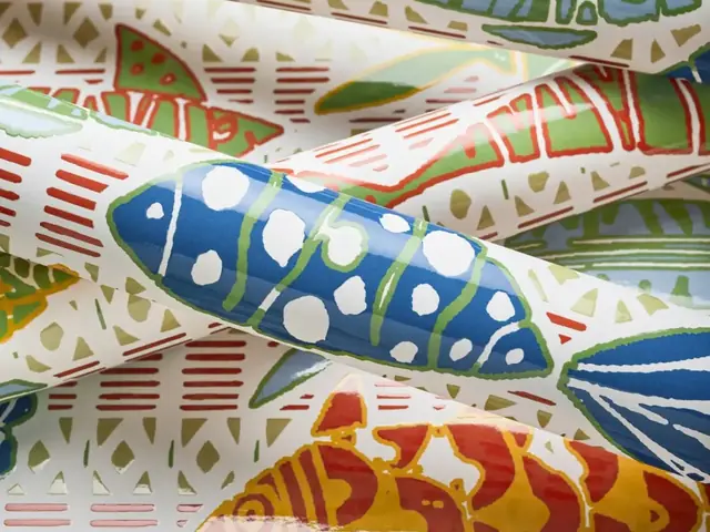 Close-up rolls of colourful fish wallpaper showing print scale and detail