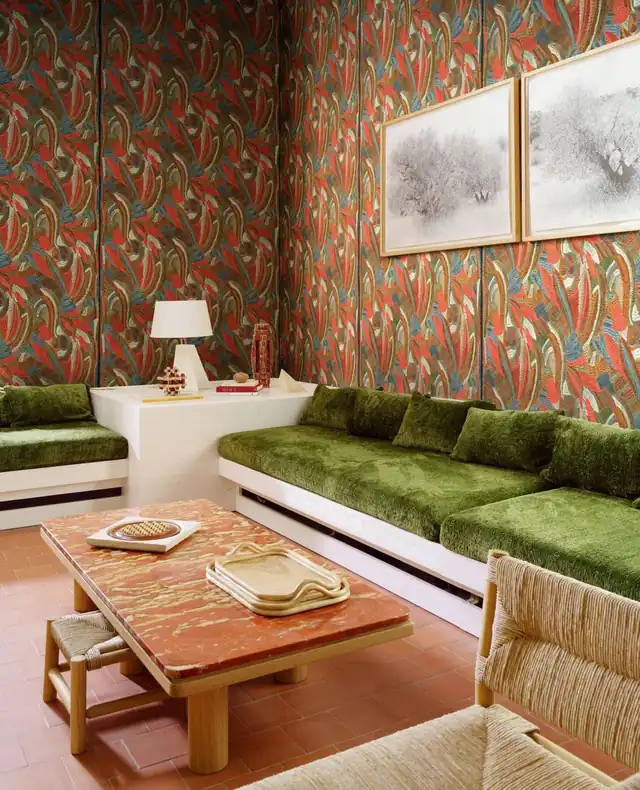 Orange and green patterned wallpaper in a layered living room