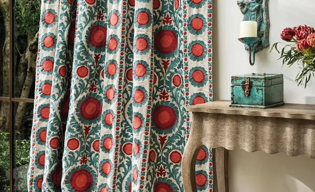 Full-length Osborne and Little patterned curtains in red, teal and neutral tones