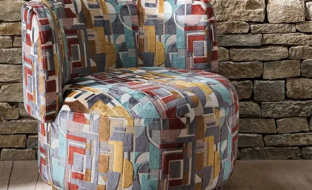 Osborne and Little multicoloured upholstery fabric on a curved chair