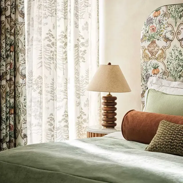 Osborne & Little sheer curtains layered with patterned curtains in a bedroom