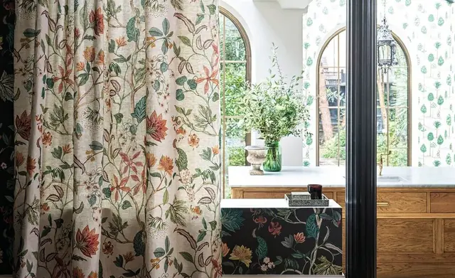 Osborne and Little patterned curtain with a coordinating wallcovering in a bright room