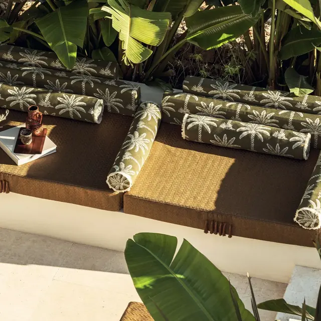 Coordinated patterned and plain outdoor fabrics on poolside seating