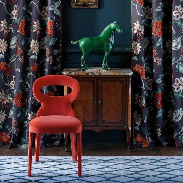 Large-scale floral patterned curtain fabric framing an elegant interior