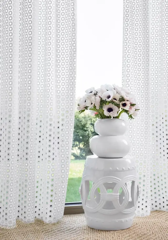 White patterned sheer fabric showing its decorative weave against natural light