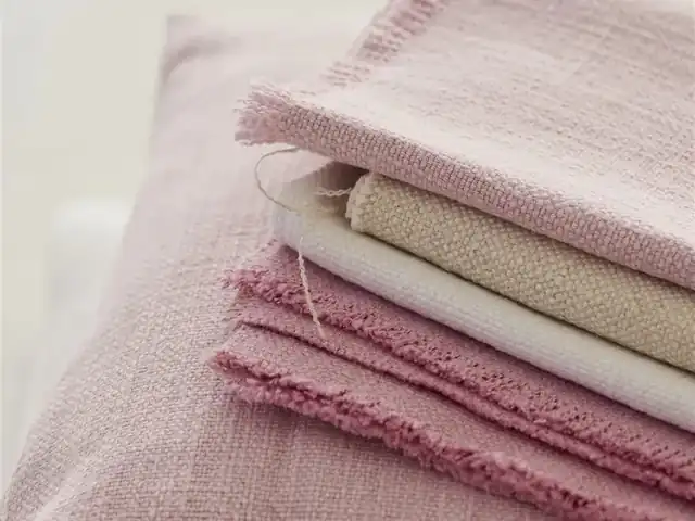 Layered pink and cream fabric samples showing woven texture
