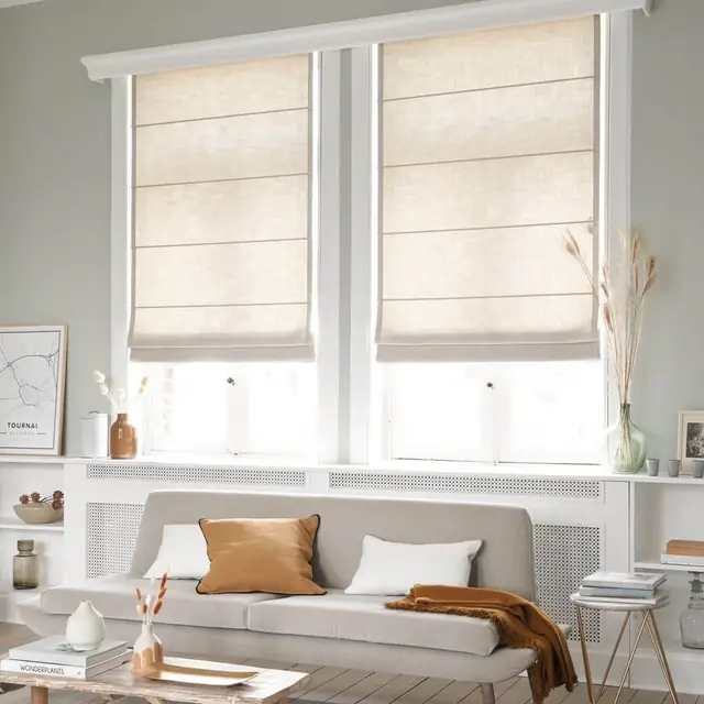 Neutral plain Roman blinds filtering daylight across three windows