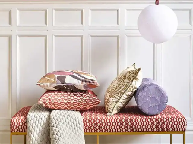 Red and cream patterned bench with coordinating cushions and draped fabrics