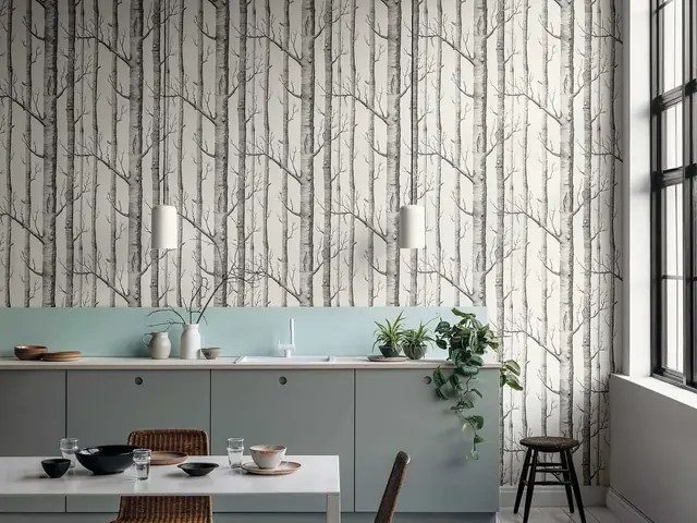 Monochrome woodland wallpaper with slender repeating trees in a modern kitchen