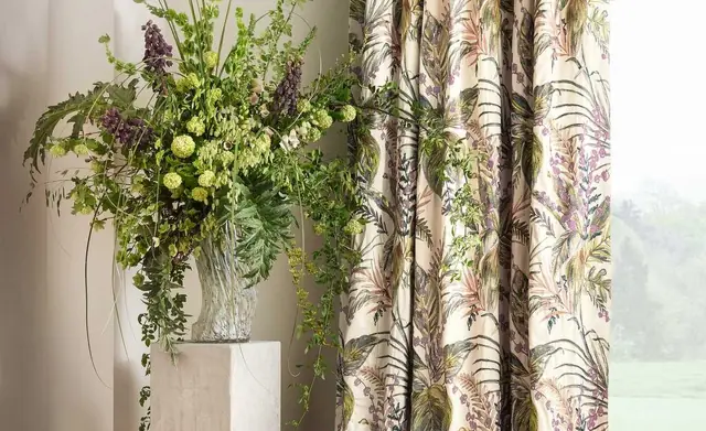 Full-length Romo patterned curtains beside a bright window