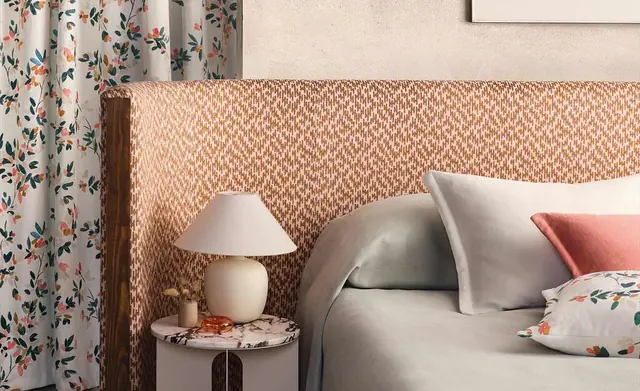 Romo fabric layered across curtains, an upholstered headboard and cushions