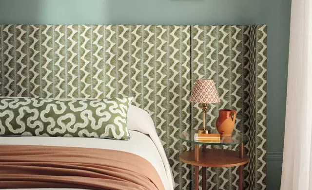 Curved upholstered headboard and cushions in coordinated Romo fabrics