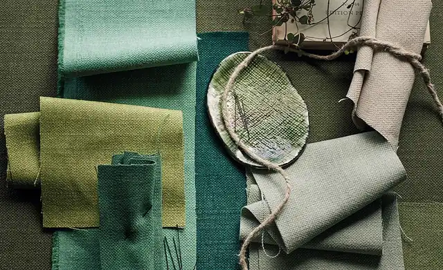 Layered green and neutral Linara fabric samples showing woven texture