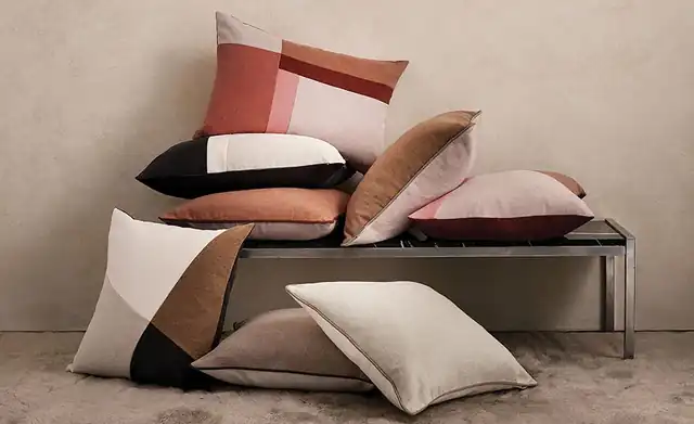 Plain and geometric patchwork Romo Linara cushions in pink, rust and cream shades