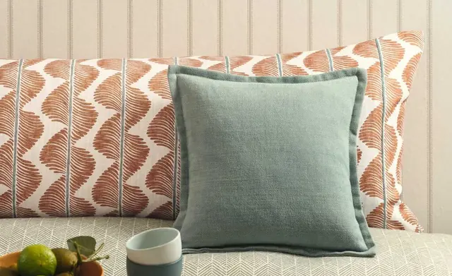 Romo cushions finished with contrasting piping and coordinated patterned fabrics