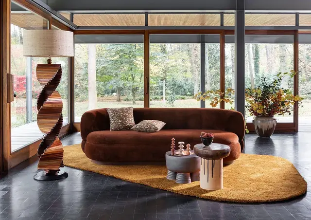 Curved contemporary sofa upholstered in rust-coloured velvet fabric