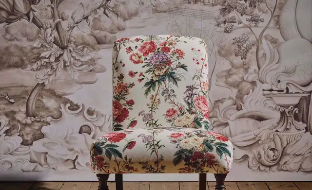 Custom chair upholstered in floral fabric against Sanderson wallpaper