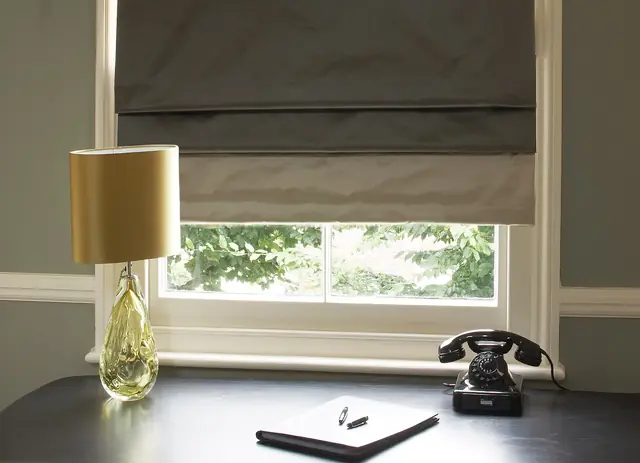 Plain satin fabric used for a tailored Roman blind in a traditional interior