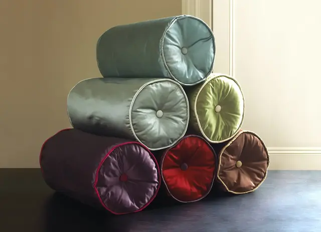 Round silk satin cushions showing the fabric's colour, sheen and softly gathered surface
