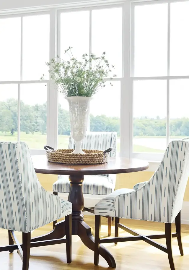 Pale striped linen upholstery on dining chairs