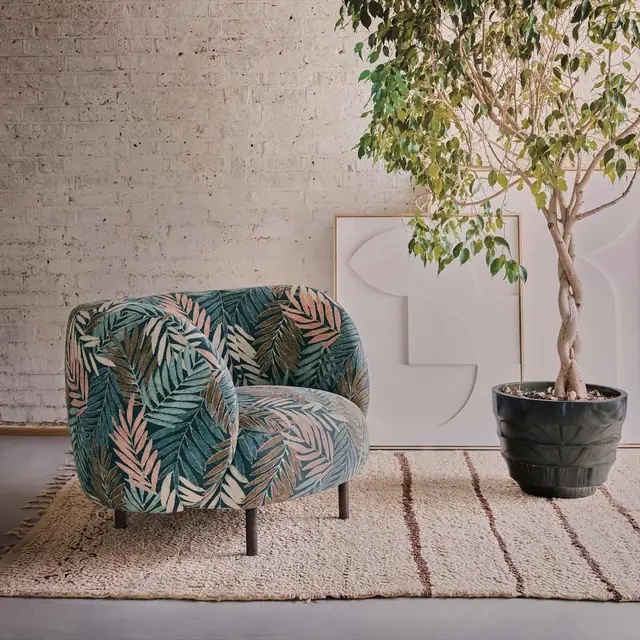 Armchair upholstered in a restrained blue and green leaf fabric
