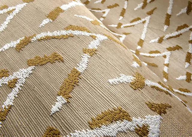 Gold and white embroidery on a natural sisal wallcovering