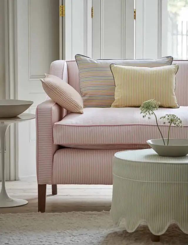 Pink ticking stripe upholstery fabric on a sofa with striped cushions