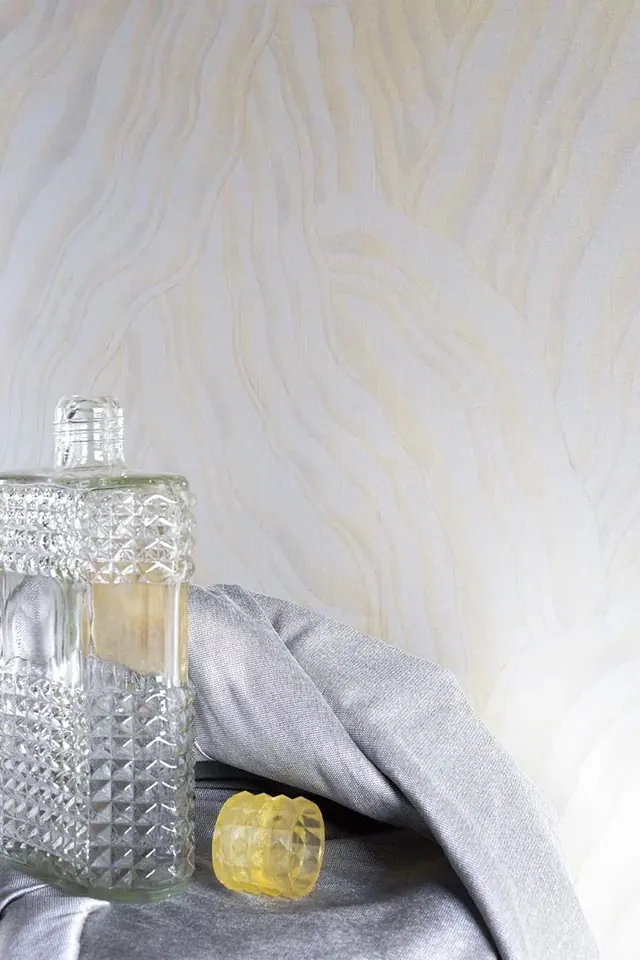 Elegant cream wallpaper with a subtle flowing pattern and light reflective detail