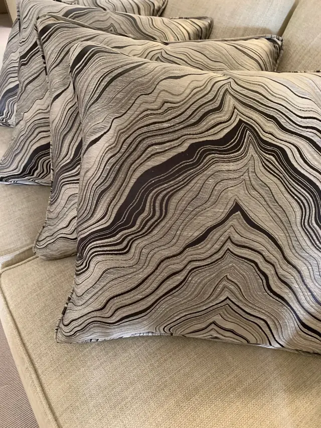 Coordinated bespoke cushions in a flowing monochrome patterned fabric