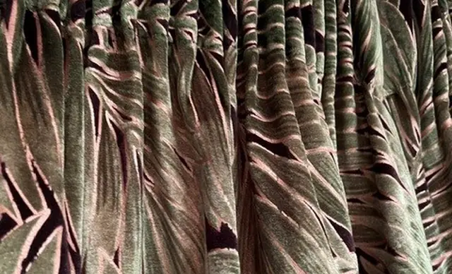 Close-up of pleated curtains made by TM Interiors in a green and pink botanical fabric