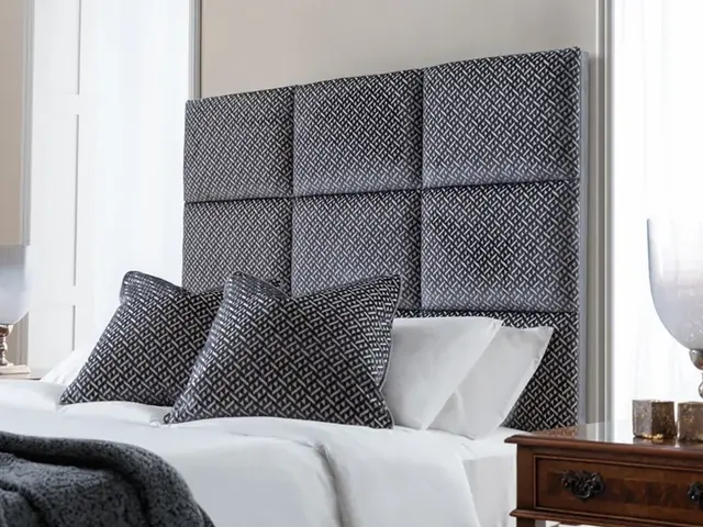 Geometric panelled upholstered headboard in dark patterned fabric