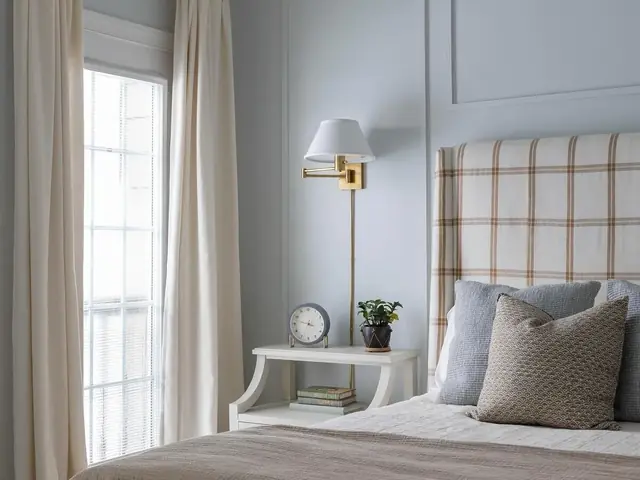 Tall checked upholstered headboard in a neutral bedroom