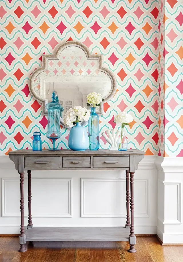 Bright pink and coral patterned wallpaper in a colourful interior