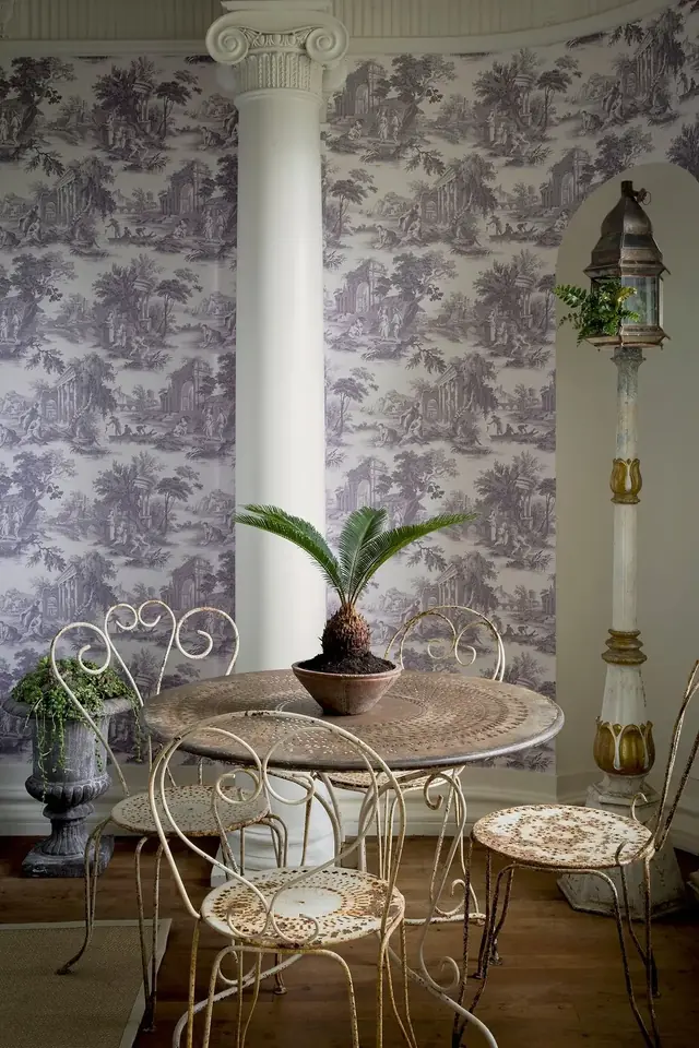 Lilac Toile de Jouy wallpaper with pastoral figures and classical ruins in an elegant dining area