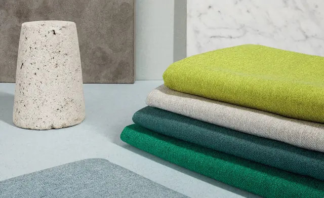 Stack of Trevira furnishing fabrics in green, blue, grey and neutral colours
