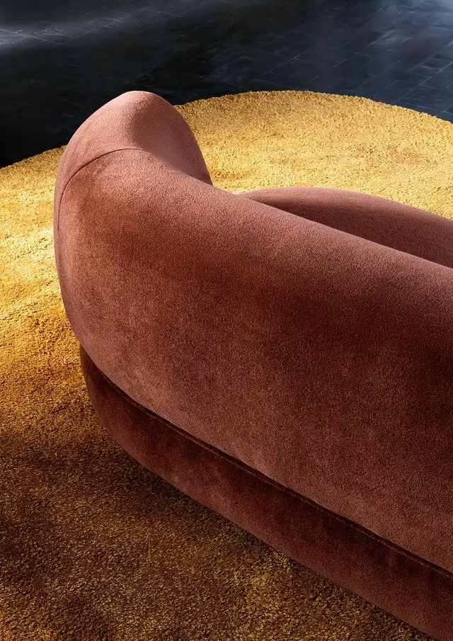 Close view of rust velvet upholstery showing the direction and texture of the pile