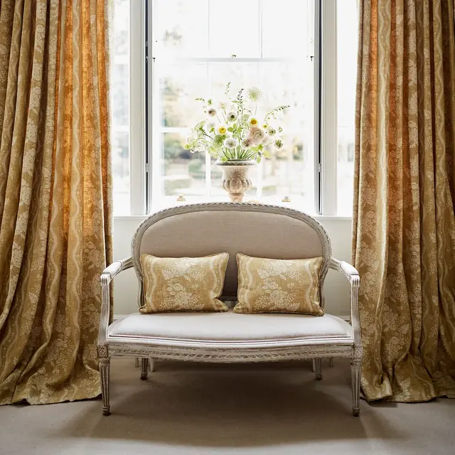 Gold patterned viscose blend curtains and cushions in a traditional bedroom