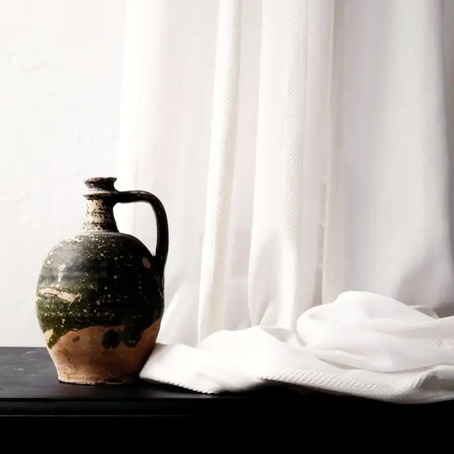 Close view of translucent voile fabric showing its open weave and softly filtered light