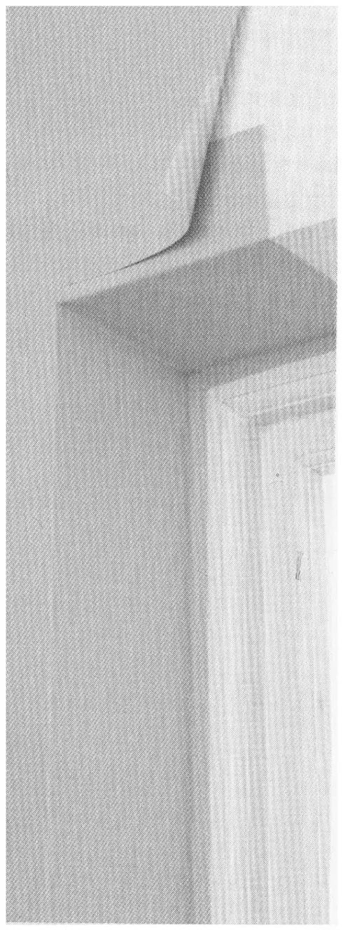 Photograph showing wallpaper folded from the wall face into a recessed window reveal
