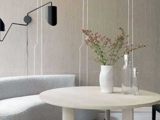 Warm grey sculptural wallpaper in a restrained dining area