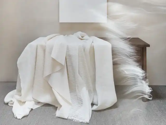 White and off-white fabrics draped together to show contrasting textures