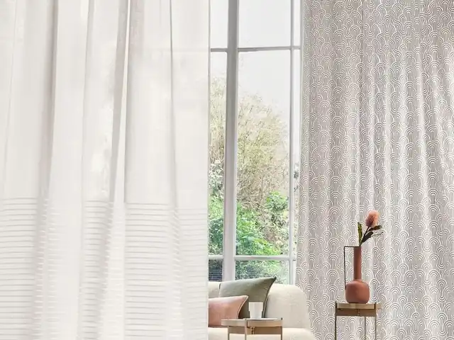 White sheer curtains filtering daylight in a pale room