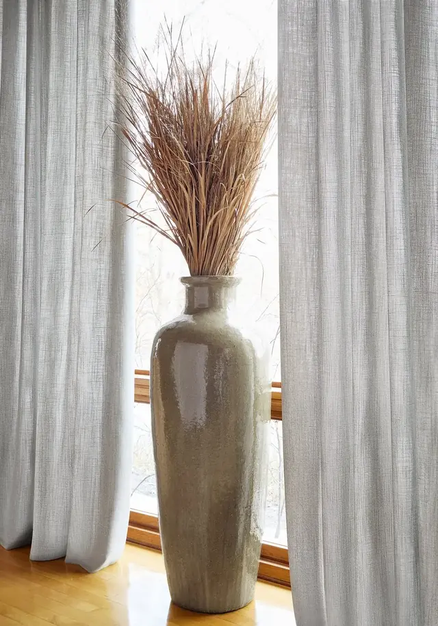 Natural wide-width linen curtains across a large contemporary window