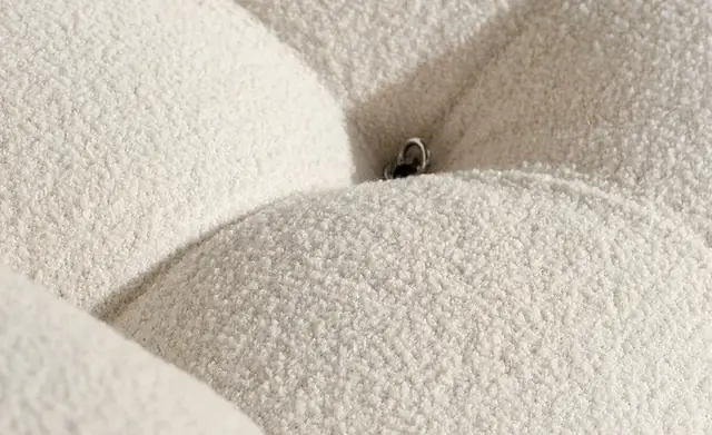 Close-up of a soft cream bouclé furnishing fabric with looped texture