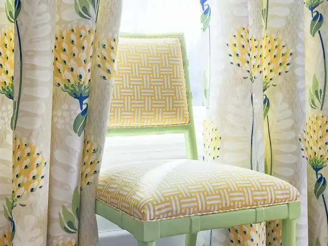 Yellow floral curtains beside a pale green chair with yellow and white geometric upholstery