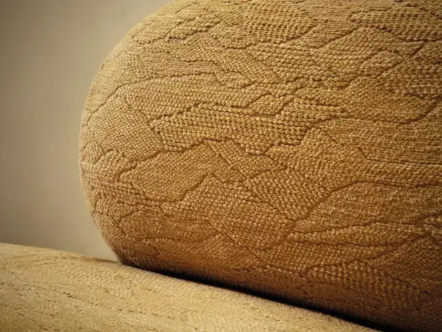 Close-up of ochre upholstery with a raised curving pattern