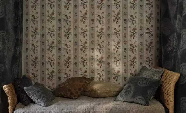 Layered Zoffany fabric, wallpaper, drapery and cushions in a furnished interior