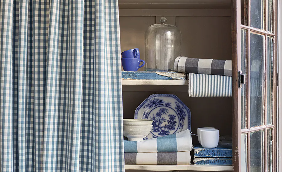 Grand Millenial styling with heirloom furniture, china on display and gingham fabric