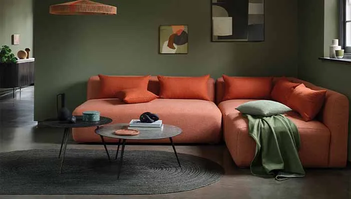 A bold and vibrant orange velvet sofa, adding warmth and energy to a modern living space. Ideal for burnt orange velvet upholstery fabric.